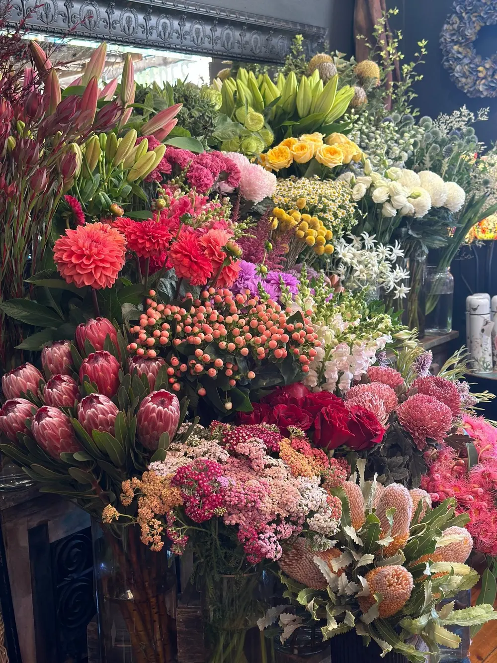 Display of fresh proteas, dahlias, roses and seasonal flowers inside the Wilde Ivy shop